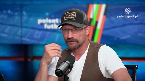 Mężczyzna w okularach i czapce z daszkiem, mówiący do mikrofonu.