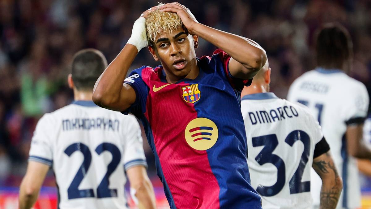 Piłkarz w koszulce Barcelony z blond fryzurą trzyma się za głowę w geście rozpaczy lub frustracji podczas meczu.