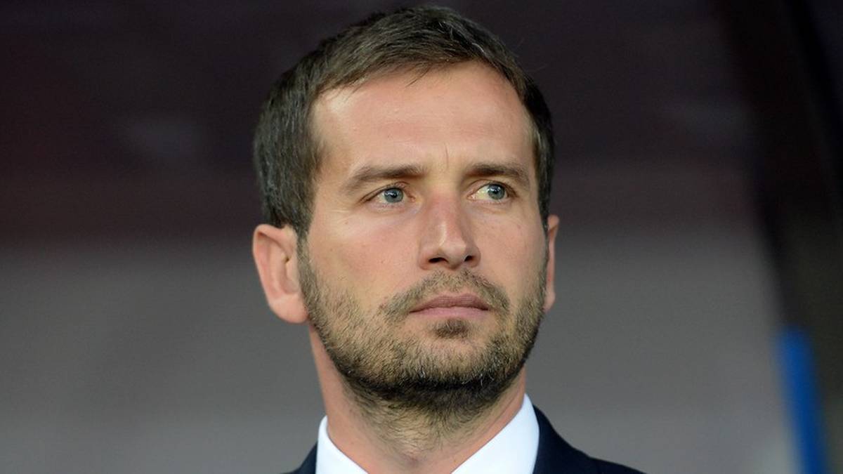 Portret mężczyzny w garniturze, patrzącego przed siebie.