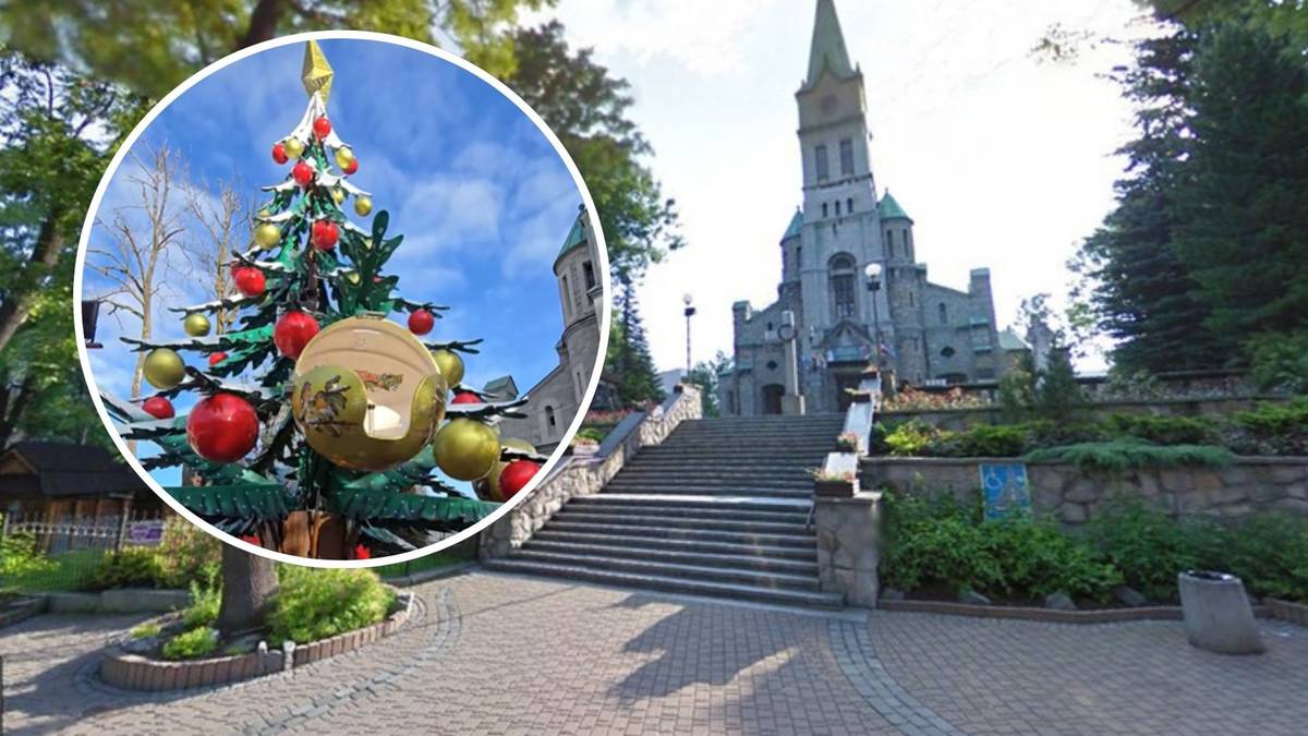 Ozdobiona choinka w okręgu, w tle kościół z kamiennymi schodami.