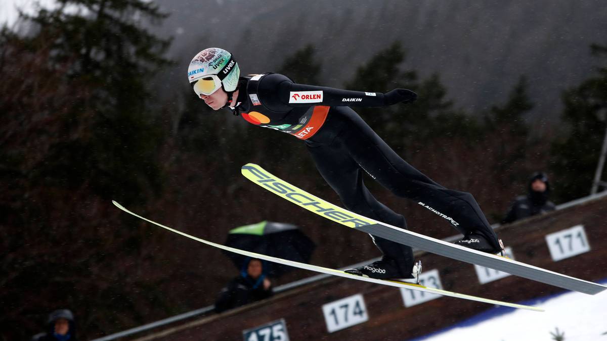 Skoczek narciarski w locie podczas zawodów.