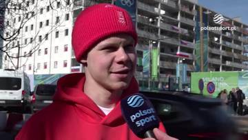 Michał Niewiński, ubrany w czerwoną czapkę i bluzę z kapturem, udziela wywiadu z mikrofonem Polsat Sport.