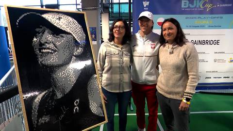 Portret tenisistki wykonany z klocków, obok stoją trzy osoby.