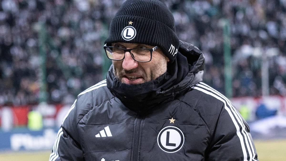 Mężczyzna w czapce z daszkiem i okularach, ubrany w kurtkę sportową z logo Legii Warszawa.