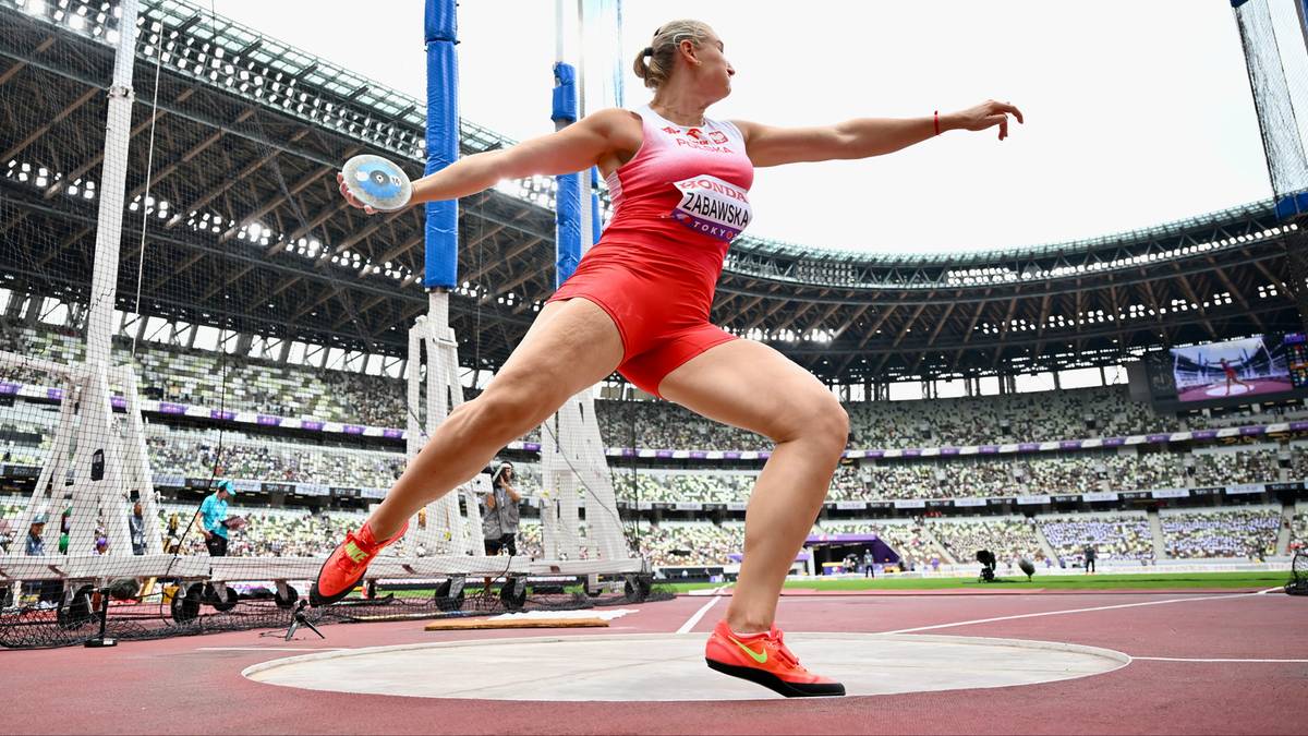 Lekkoatletka podczas rzutu dyskiem na stadionie.