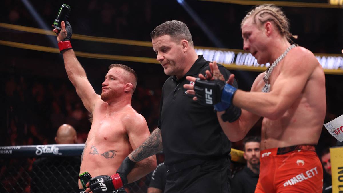 Dw&oacute;ch zawodnik&oacute;w MMA i sędzia na ringu po walce.