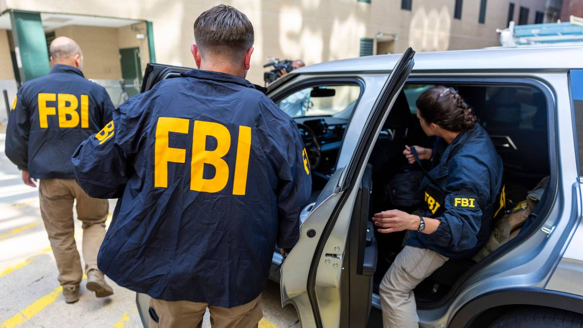 Trzech agentów FBI wysiada z samochodu, jeden z nich otwiera drzwi.