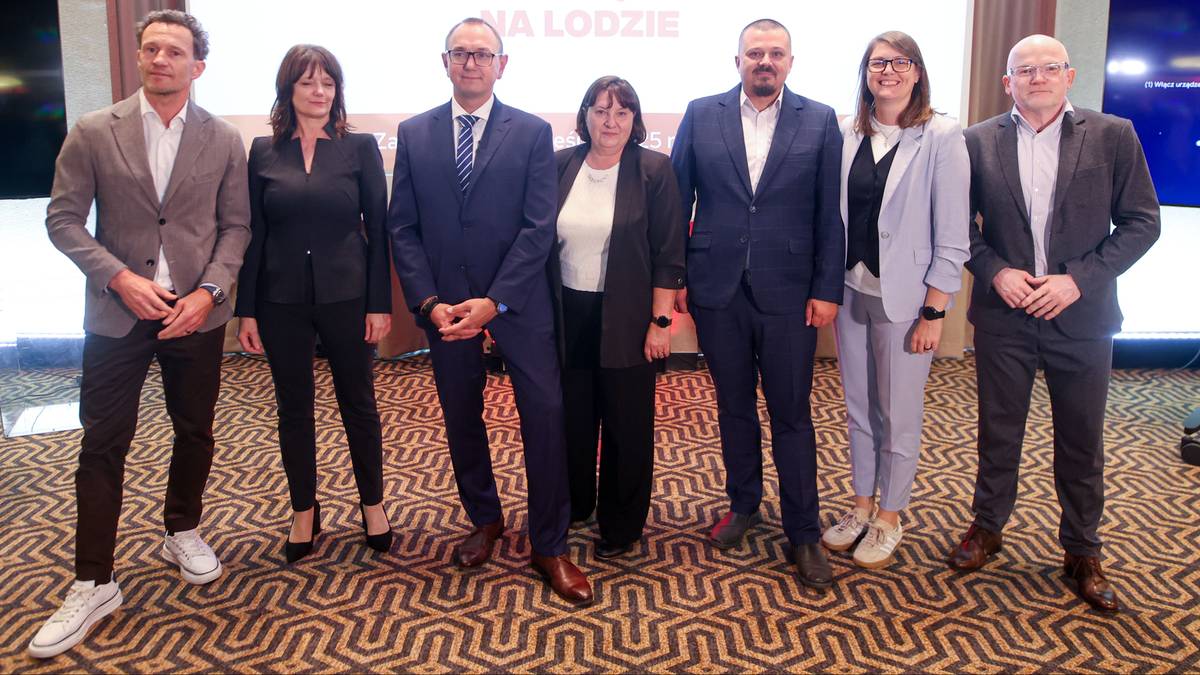 Grupa siedmiu osób stojąca razem, patrząca w stronę aparatu.