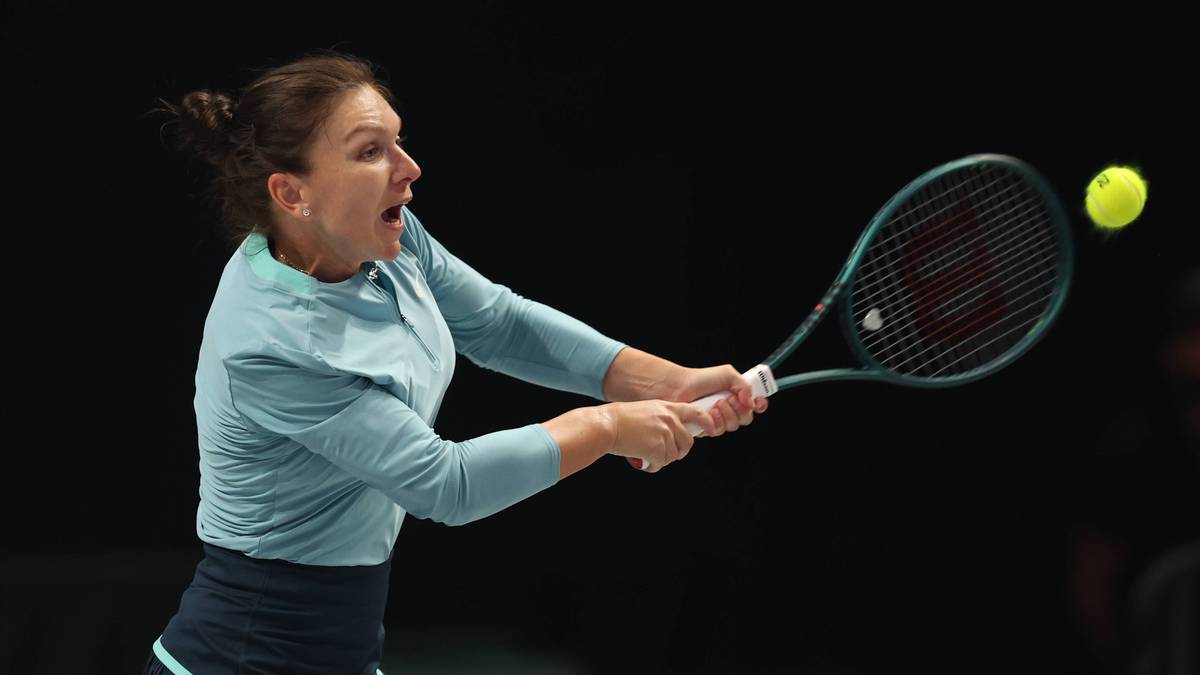 Kobieta grająca w tenisa, uderza rakietą piłkę, z determinacją na twarzy.