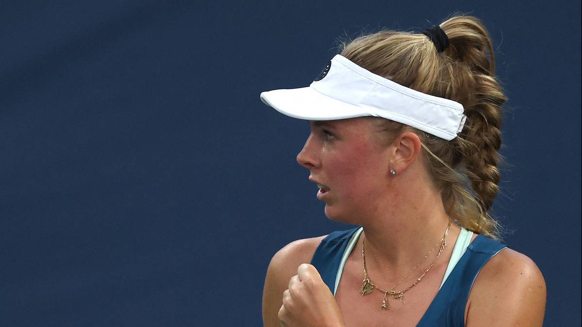 Profilowa fotografia tenisistki w białej czapce z daszkiem i w stroju sportowym, patrzącej w bok.