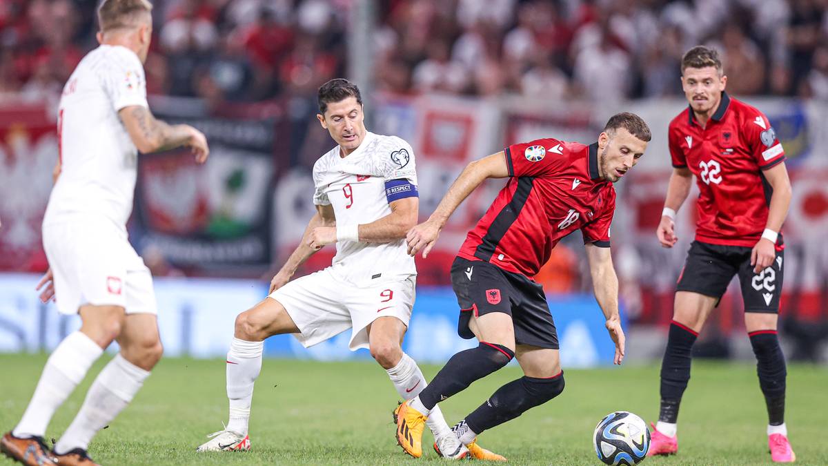 Piłkarze reprezentacji Polski i Albanii walczą o piłkę na boisku podczas meczu piłki nożnej.