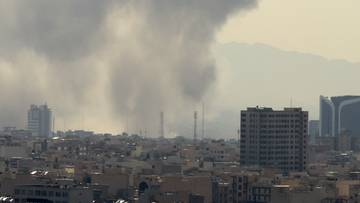 Kłęby dymu unoszące się nad zabudowaniami miejskimi.
