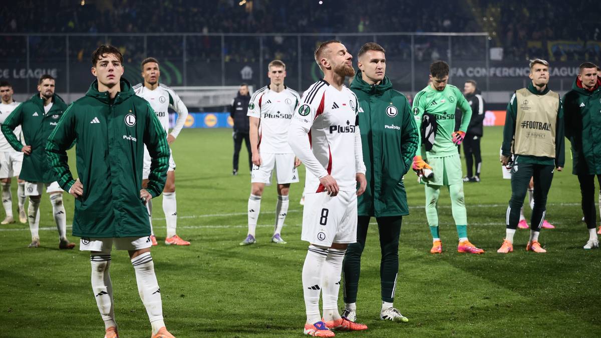 Piłkarze w zielonych i białych strojach stoją na boisku piłkarskim