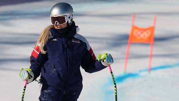 Narciarka alpejska w kombinezonie i kasku na stoku narciarskim.