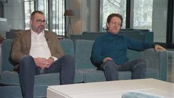 Dw&oacute;ch mężczyzn siedzi na kanapie.