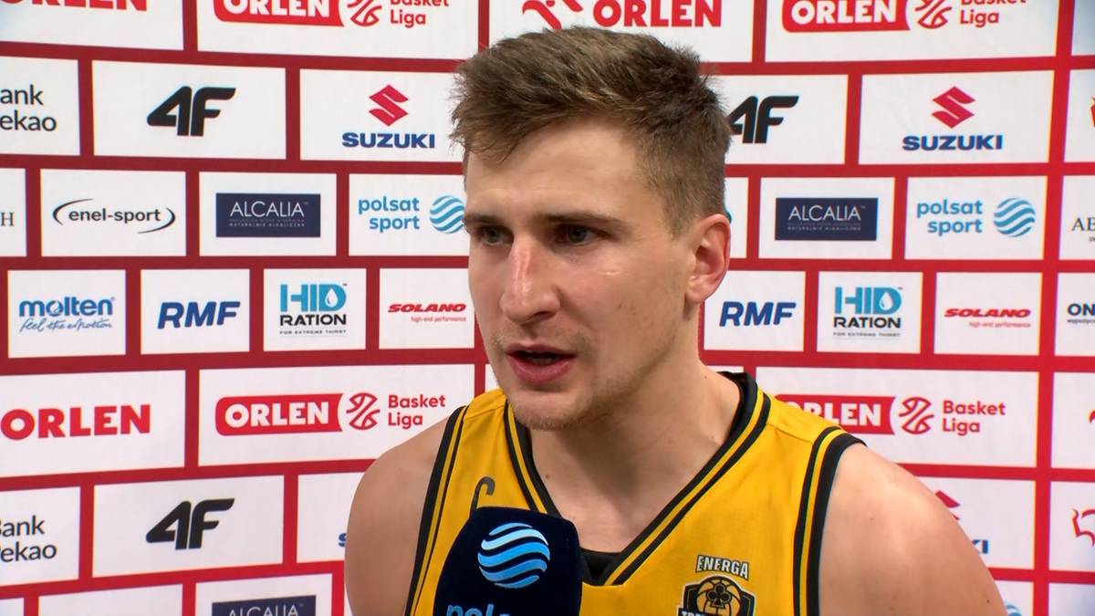 Młody mężczyzna, zawodnik koszykówki, ubrany w żółtą koszulkę, udziela wywiadu.