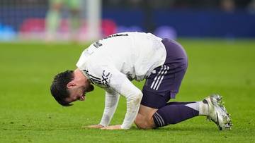 Piłkarz Manchesteru United klęczy na boisku z b&oacute;lu.