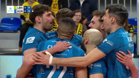 Drużyna siatkarzy Bogdanki LUK Lublin w niebieskich strojach świętuje, przytulając się nawzajem w geście radości i jedności podczas meczu.