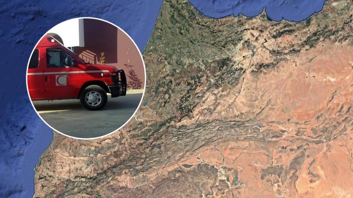 Fragment czerwonego wozu strażackiego w okręgu na tle mapy Maroka z zaznaczonymi górami.