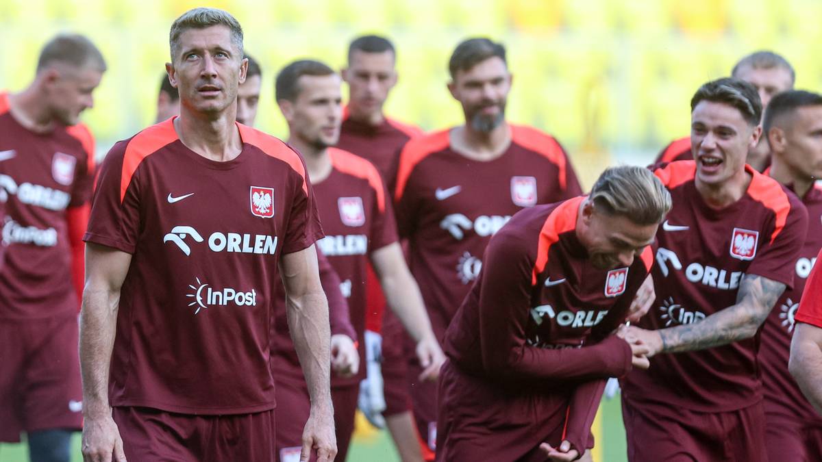 Piłkarze reprezentacji Polski w bordowych koszulkach treningowych z białym logo.