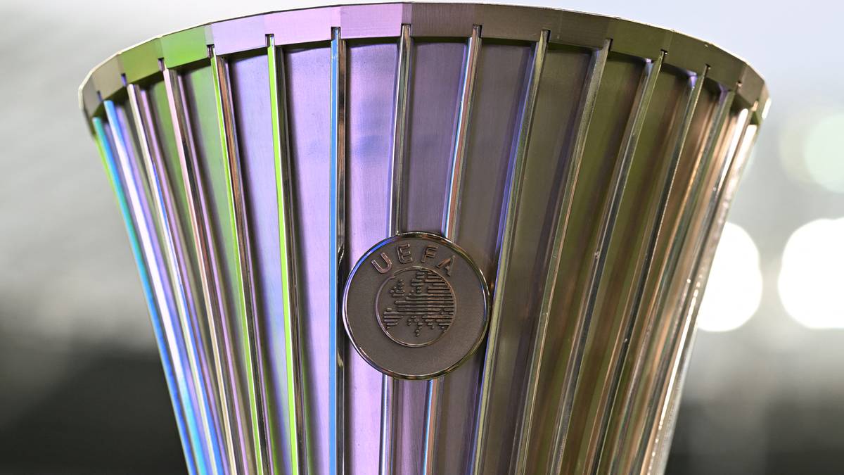 Zbliżenie na fragment metalowego pucharu, prawdopodobnie trofeum sportowego, z widocznym logo UEFA.