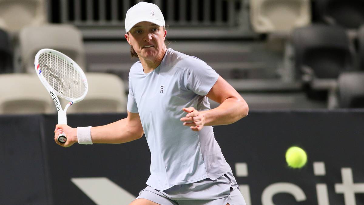 Tenisistka Iga Świątek przygotowuje się do odbicia piłki podczas meczu.