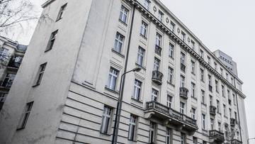 Elewacja zabytkowej kamienicy z licznymi oknami i balkonami.