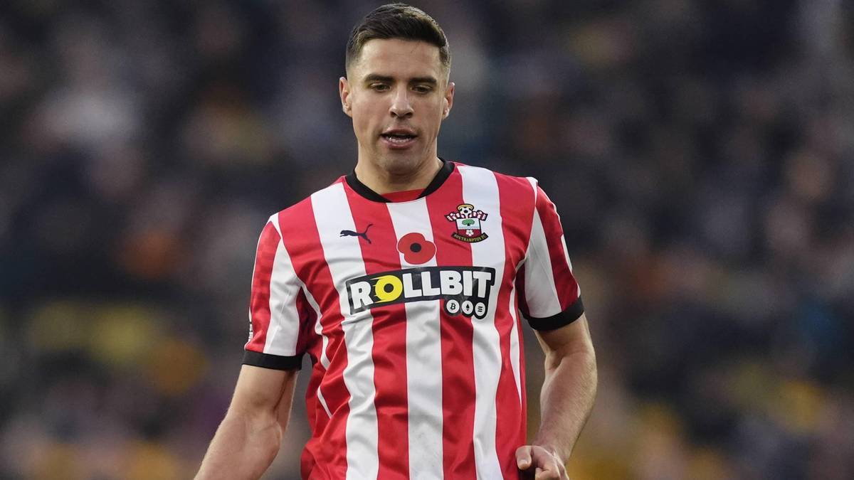 Piłkarz Jan Bednarek w czerwono-białej koszulce Southampton, widoczny od pasa w górę.