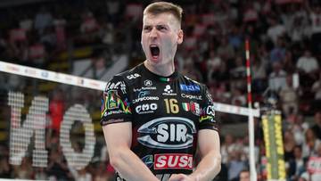 Siatkarz w czarnej koszulce z numerem 16 krzyczy na boisku podczas meczu.