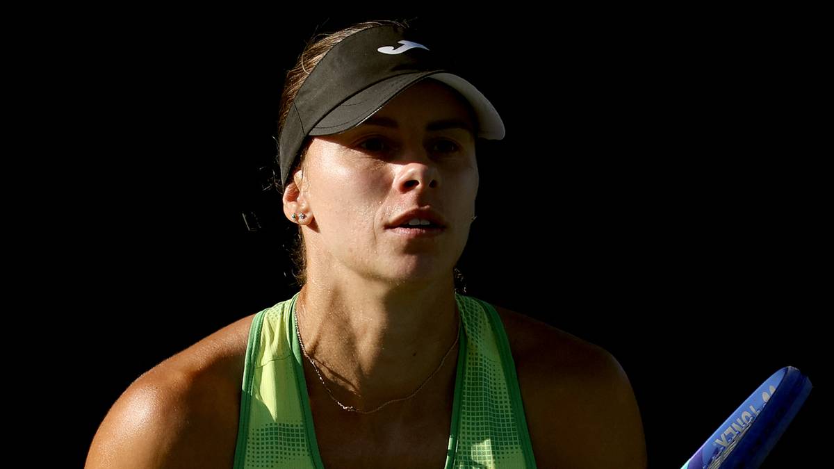 Magda Linette trzymająca rakietę tenisową, ubrana w zielony str&oacute;j sportowy.