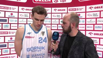 Koszykarz w białej koszulce z numerem 24 i napisem "G&oacute;rnik" rozmawia z dziennikarzem trzymającym mikrofon.