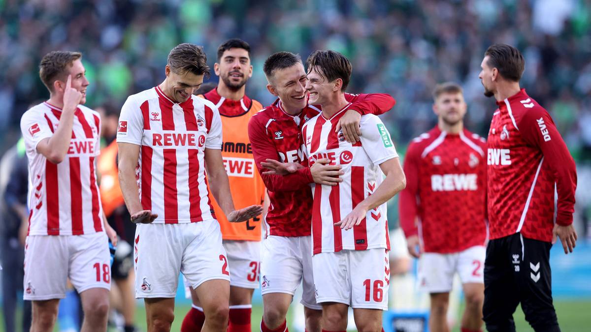 Drużyna piłkarska w biało-czerwonych strojach świętuje sukces na boisku.