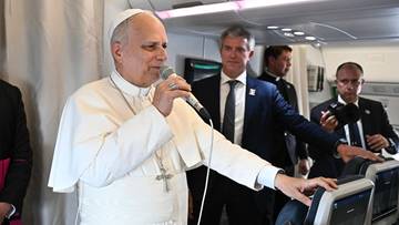 Papież Leon XIV przemawia do grupy os&oacute;b w samolocie.