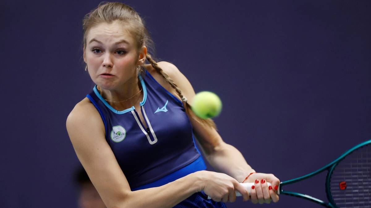 Młoda tenisistka w akcji, uderzająca piłkę rakietą podczas meczu.