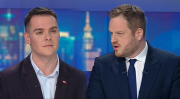 Dw&oacute;ch mężczyzn w garniturach siedzi przy stole podczas dyskusji.