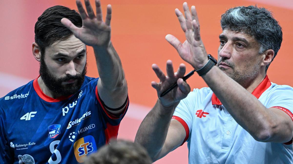 Dwóch mężczyzn w strojach sportowych, jeden w niebieskiej koszulce, drugi w białej, z uniesionymi rękami.