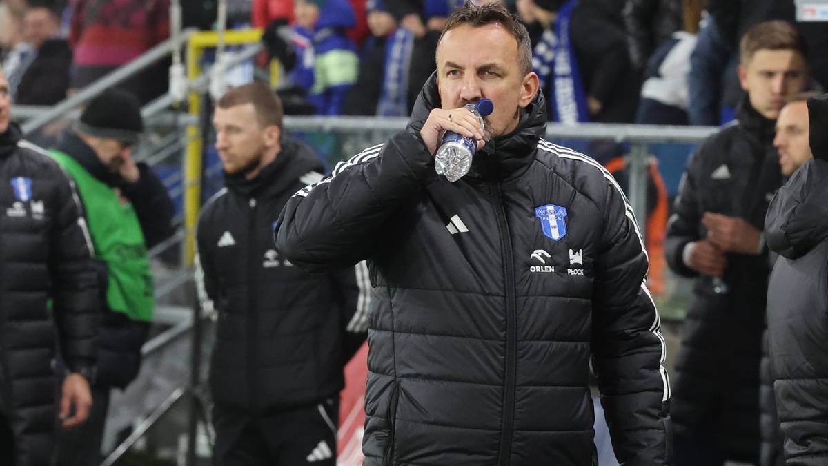 Trener Misiura pijący wodę z butelki na tle sztabu szkoleniowego