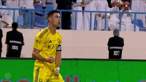 Piłkarz w ż&oacute;łtej koszulce z czarnymi pasami, z numerem 7, biegnie po boisku piłkarskim.