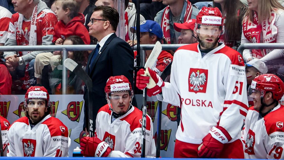 Hokeista w białej koszulce z orłem na piersi, z numerem 51 na plecach, przygotowuje się do gry.