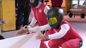 Dwie kobiety w kombinezonach narciarskich i kaskach przygotowują się do zjazdu w bobslejach.