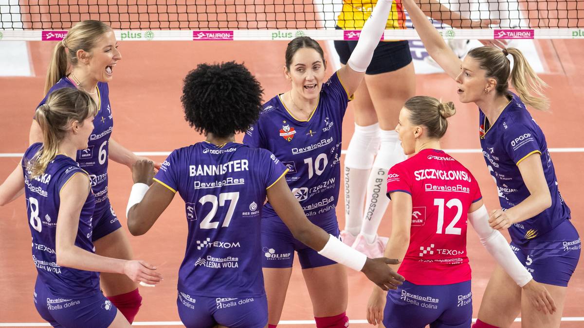 Siedem zawodniczek w niebieskich strojach siatkarskich świętuje na boisku, kilka z nich podaje sobie ręce.
