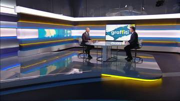 Dw&oacute;ch mężczyzn w studiu telewizyjnym siedzi przy stole, na ekranie w tle napis "graffiti".