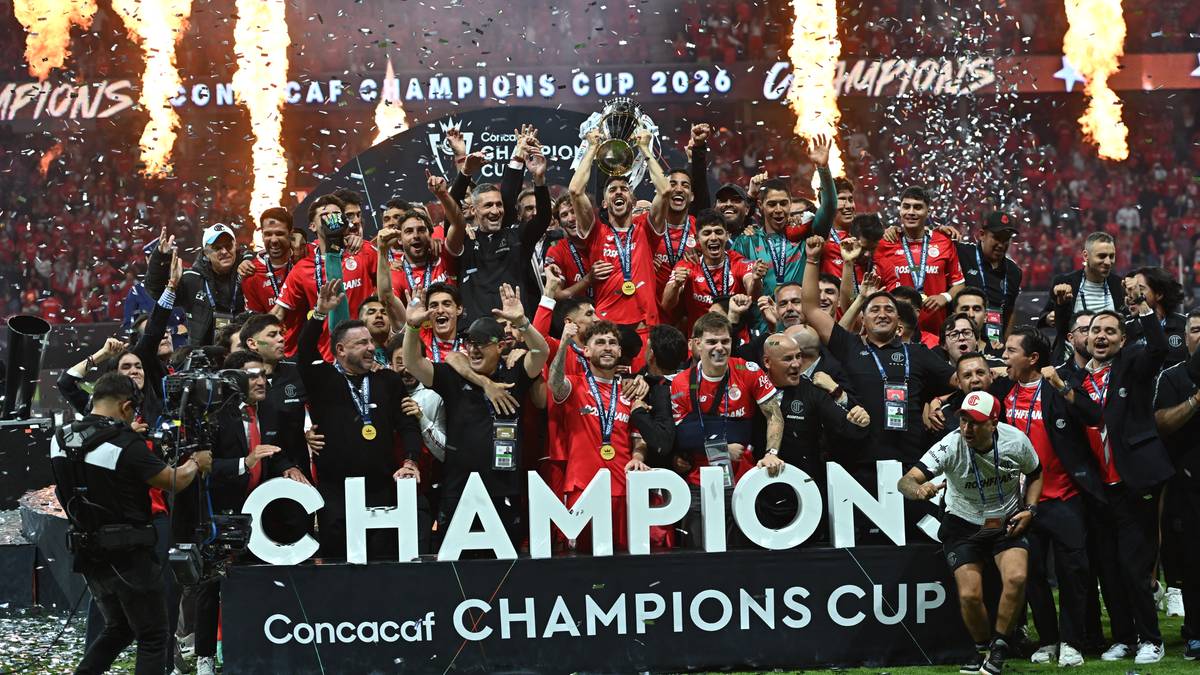 Drużyna piłkarska świętująca zwycięstwo na tle fajerwerk&oacute;w i banera "CHAMPION Concacaf CHAMPIONS CUP".