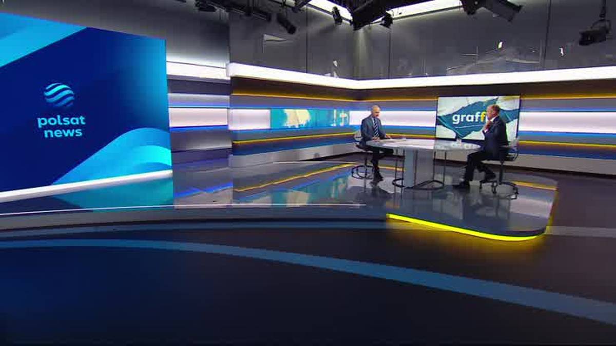 Dwaj mężczyźni siedzą przy stole w studiu telewizyjnym Polsat News. Na jednym z ekranów widnieje logo stacji, na drugim napis "graff".