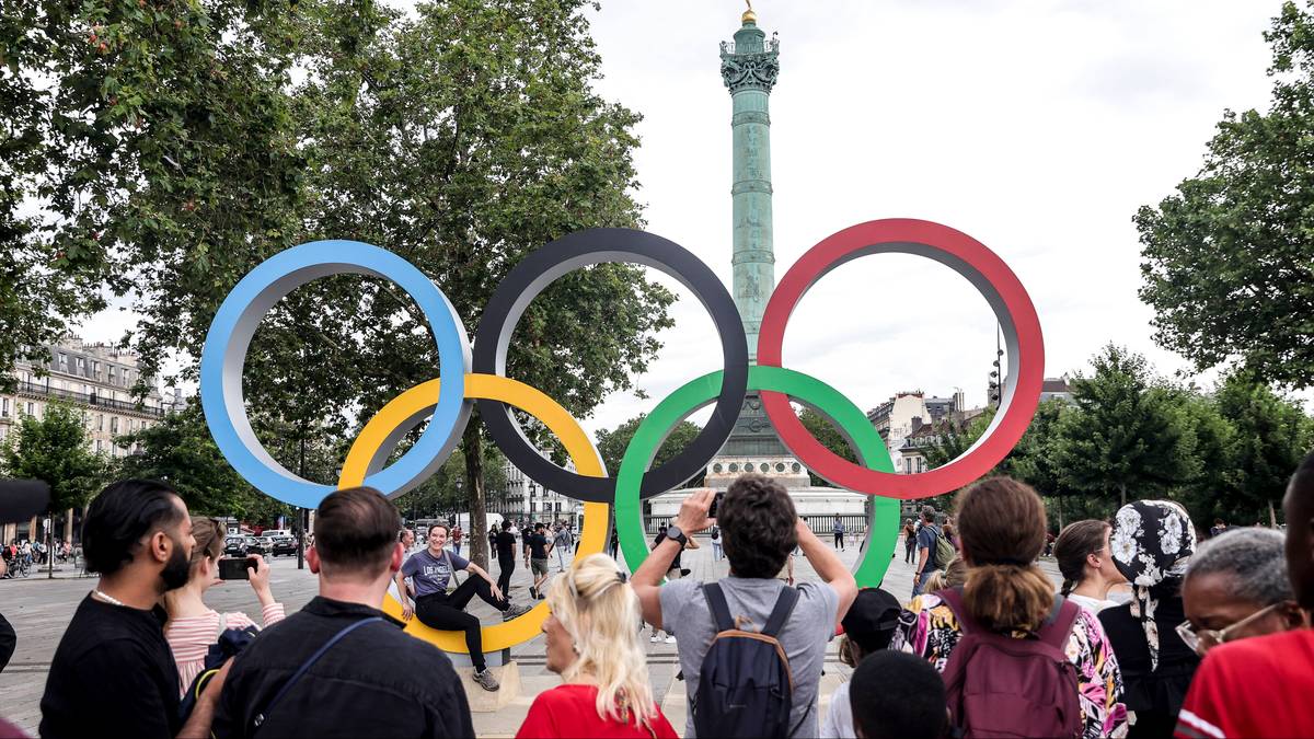 Kolorowe kółka olimpijskie z ludźmi w tle