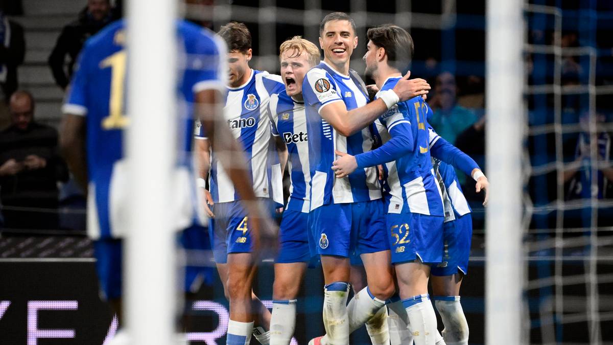 Piłkarze FC Porto w niebiesko-białych strojach świętują na boisku, niekt&oacute;rzy przytulają się nawzajem.