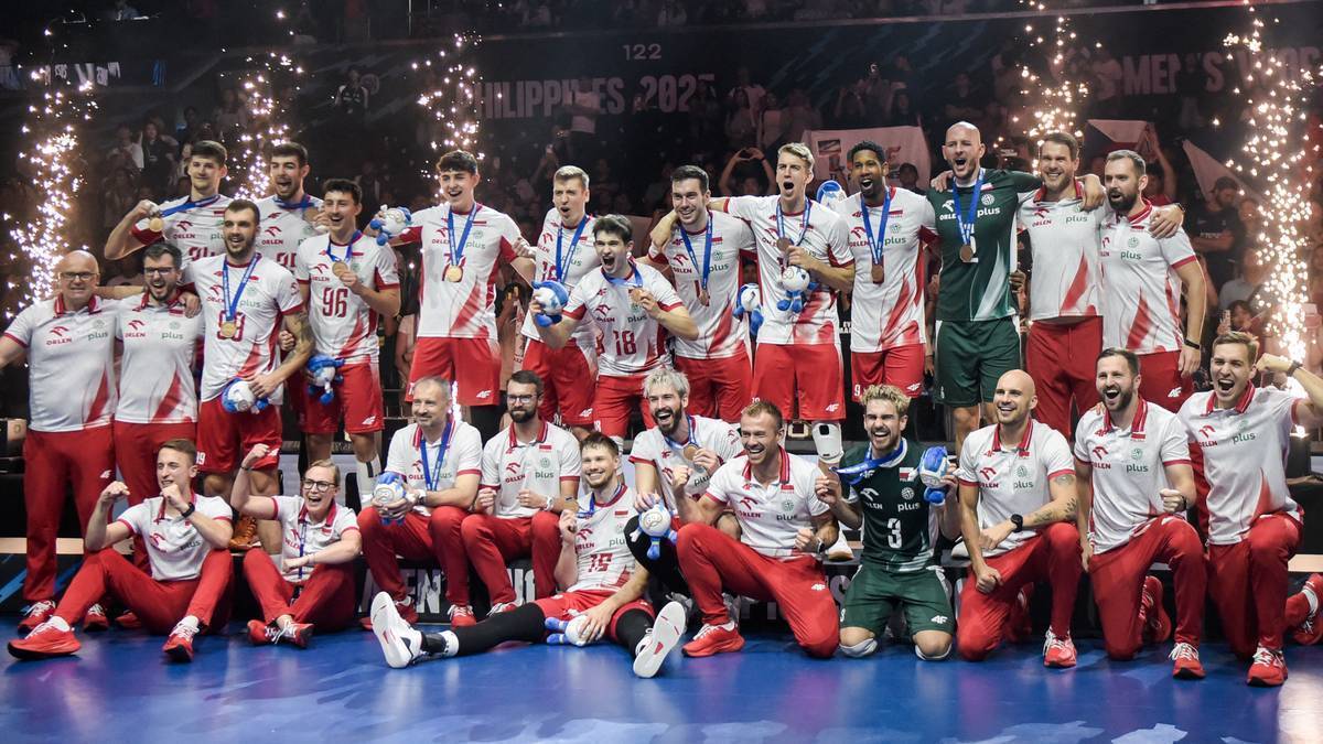 Drużyna siatkarzy w czerwonych strojach świętuje sukces, pozując do zdjęcia z medalami na tle sceny z napisem "PHILIPPINES 2025".