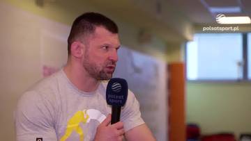 Matusz Kołecki, polski zapaśnik i zawodnik MMA, udziela wywiadu, trzymając mikrofon Polsat Sport.