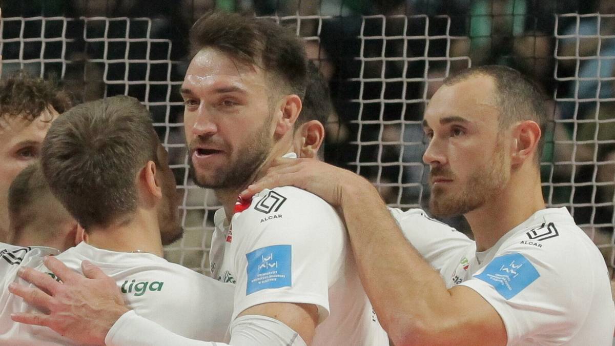 Grupa siatkarzy w białych koszulkach Indykpolu AZS Olsztyn obejmuje się i cieszy po zdobyciu punktu w meczu.