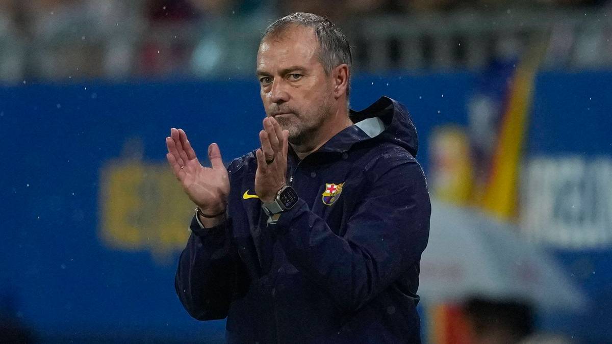 Trener FC Barcelony, Xavi Hernandez, klaska i patrzy przed siebie z zamyśloną miną.